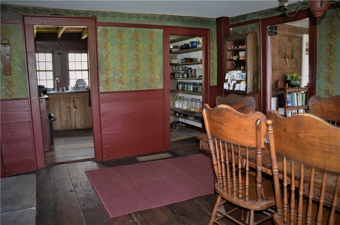 A dining room with a table and chairs and a pantry.