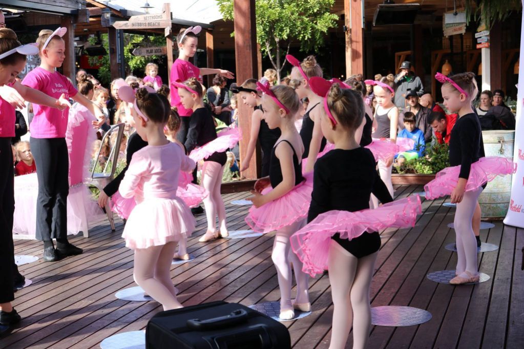 A Group of Young Girls in Pink Tutus Are Dancing on a Wooden Deck — Studi-O Dance School In Gateshead, NSW