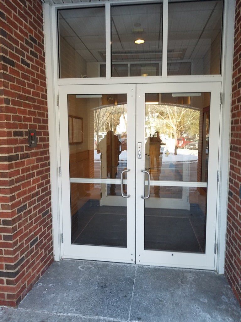 A brick building with a pair of glass doors