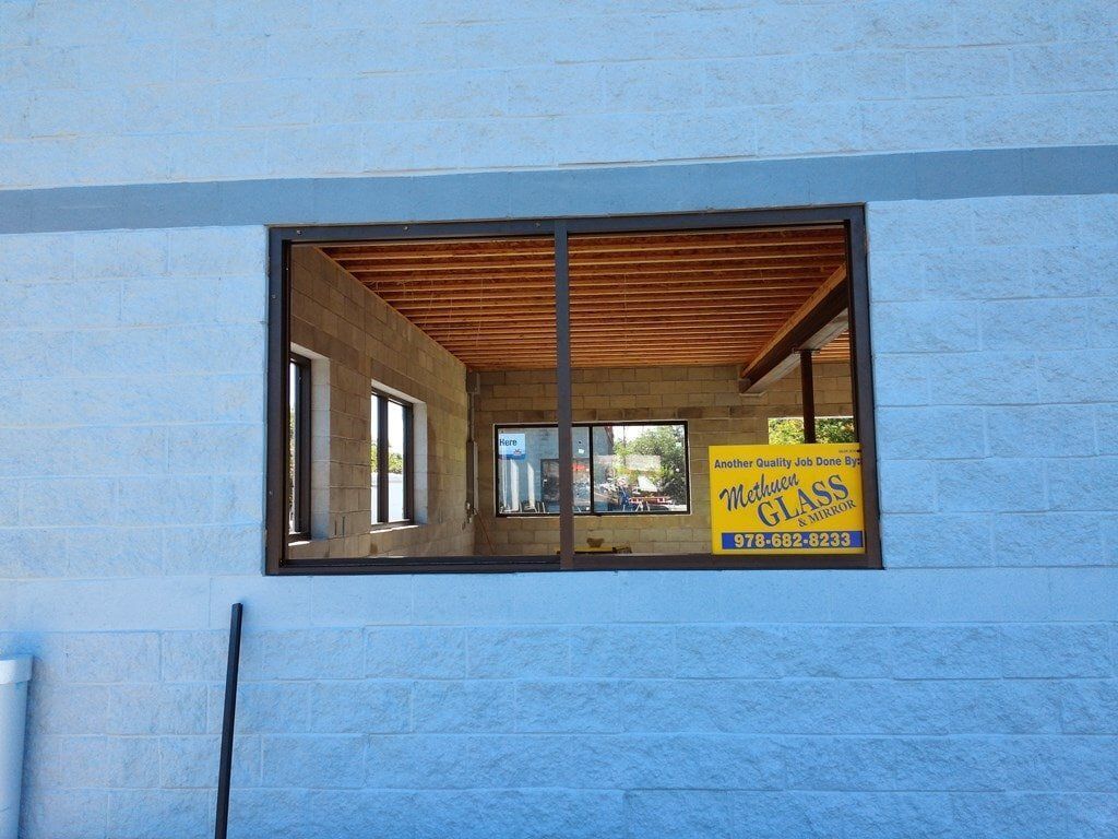 A blue building with a window and a sign that says water glass