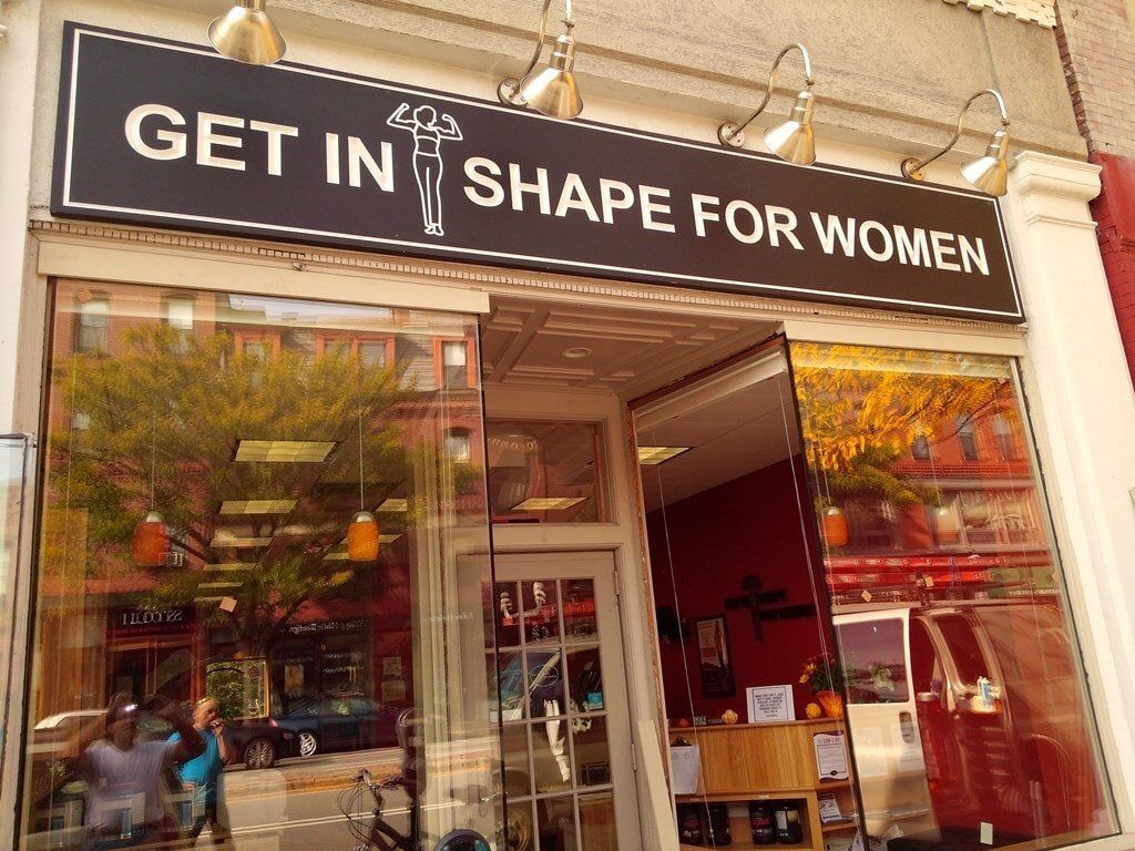A store front with a sign that says get in shape for women