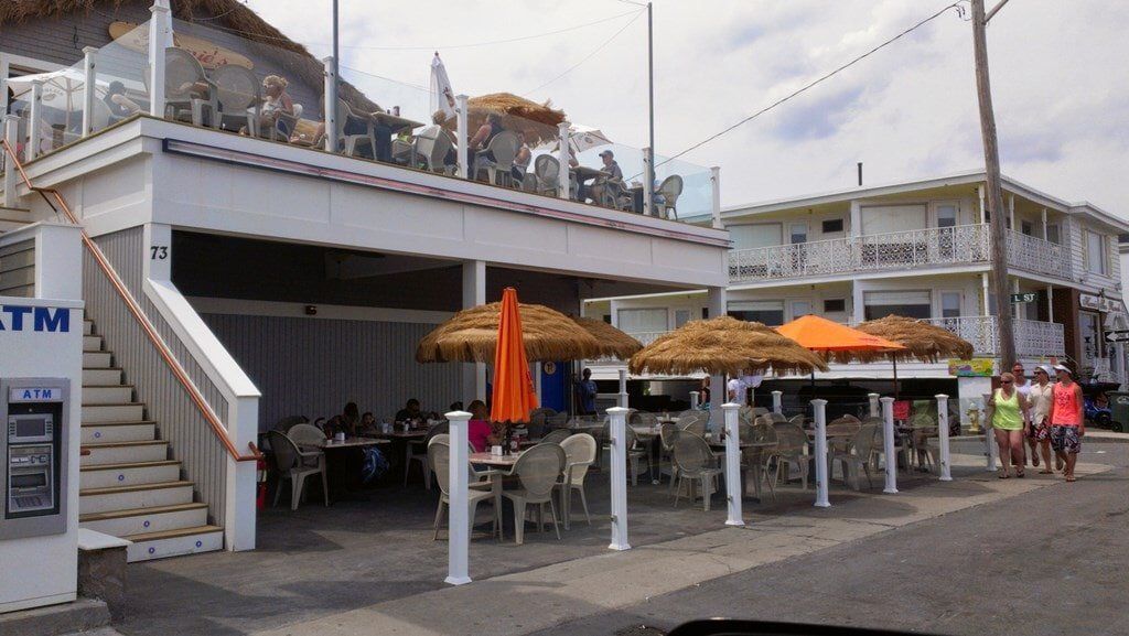 A restaurant with tables and chairs and umbrellas outside