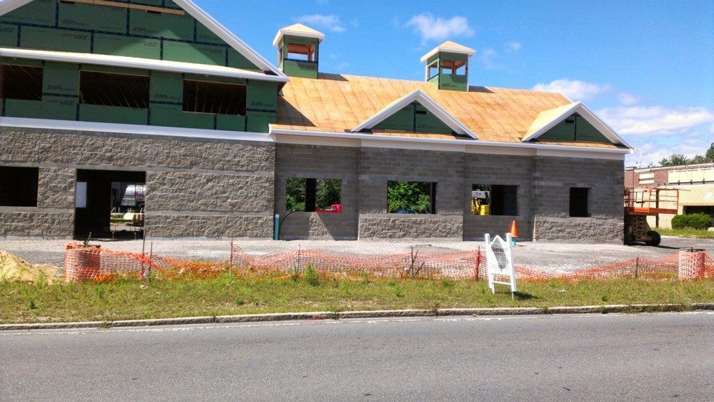 A large building is being built on the side of the road.
