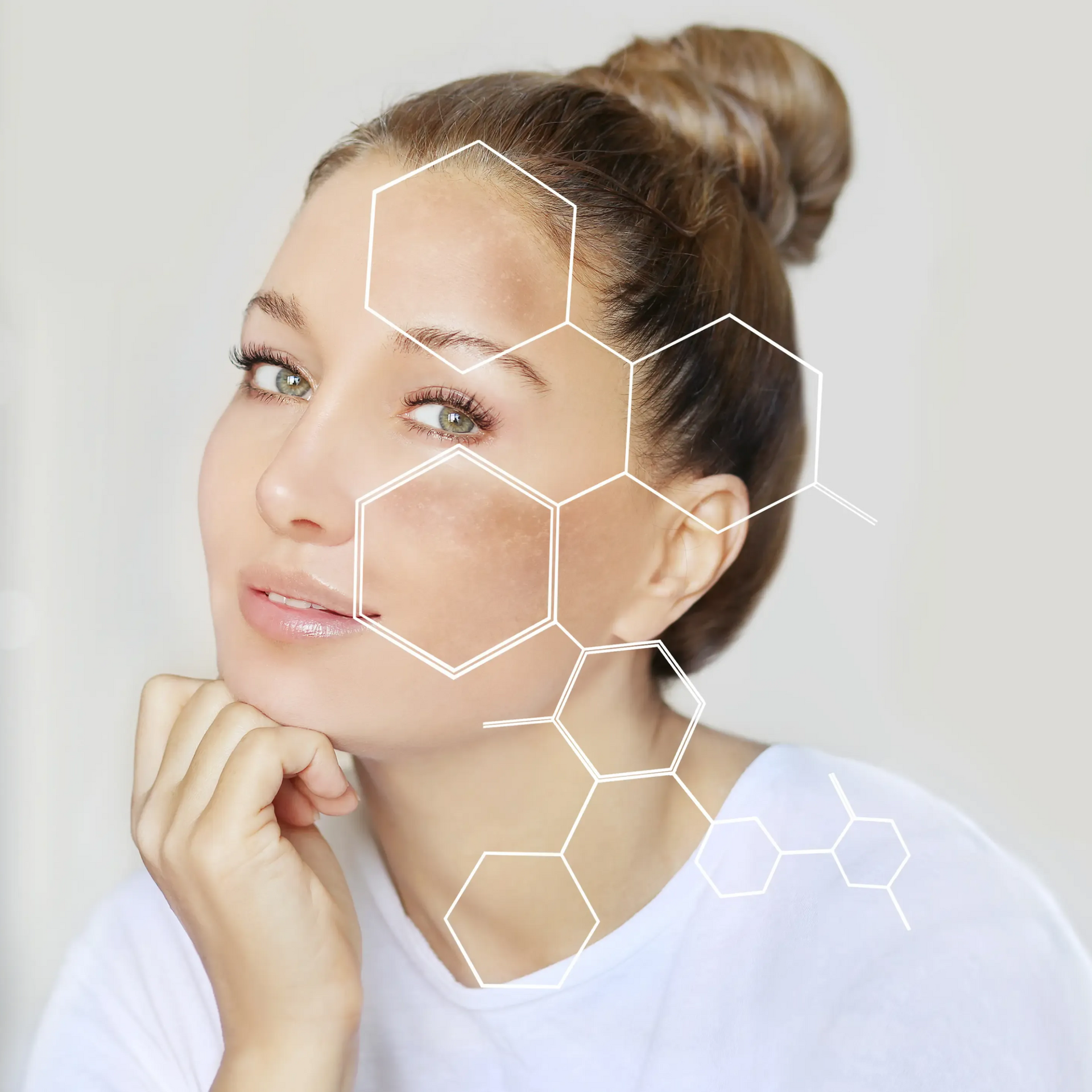 Woman with bun resting her chin on her hand beside a white hexagon overlay graphic