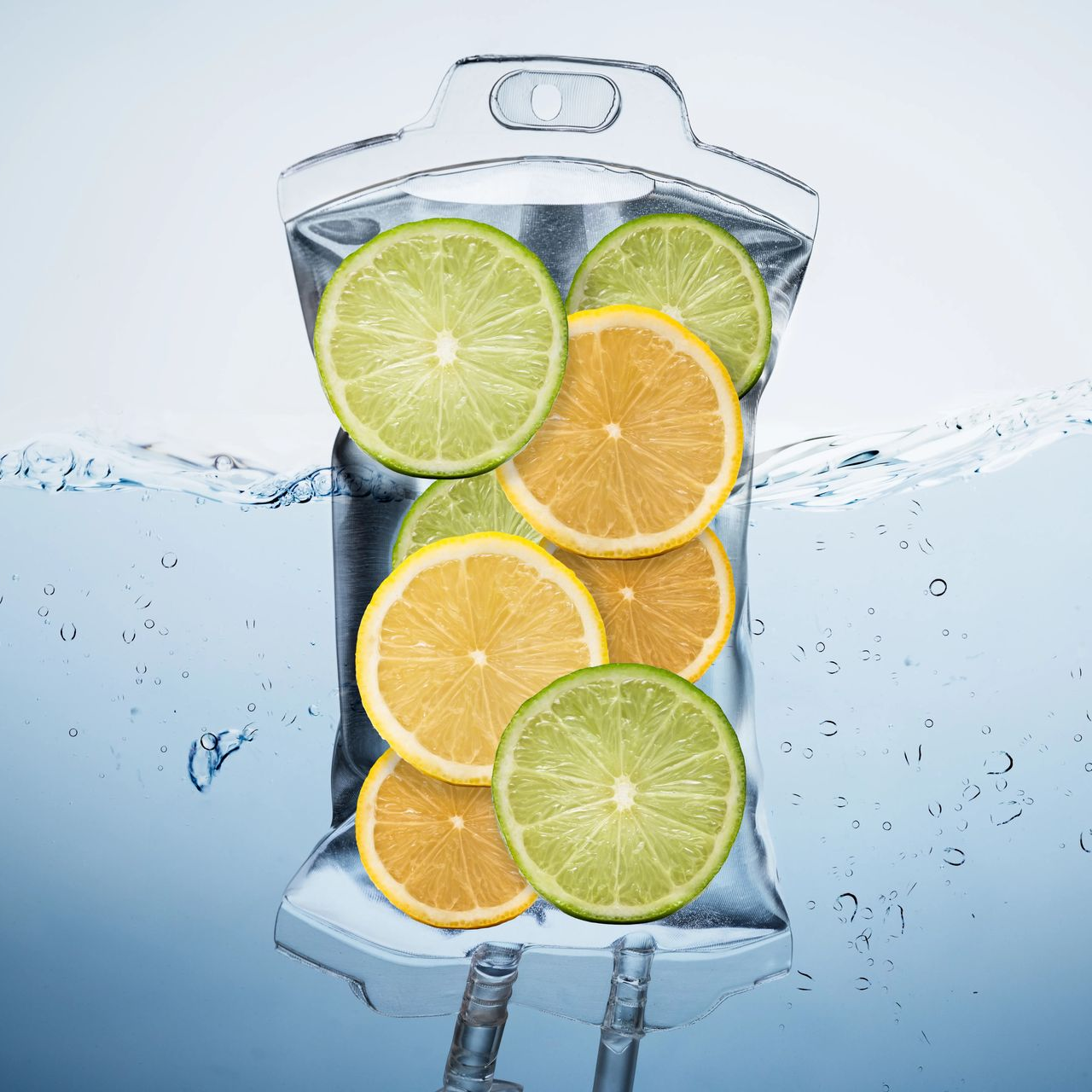 Transparent drink pouch filled with lemon and lime slices, with water splashing around it.