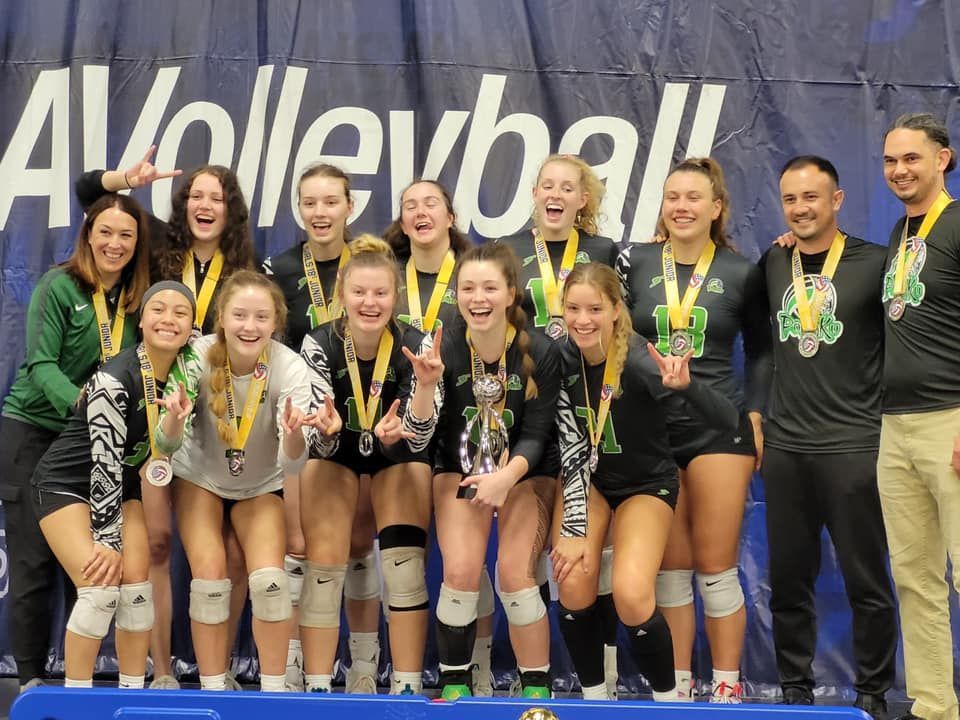 Pohaku Volleyball Club team smiling with medals and a trophy