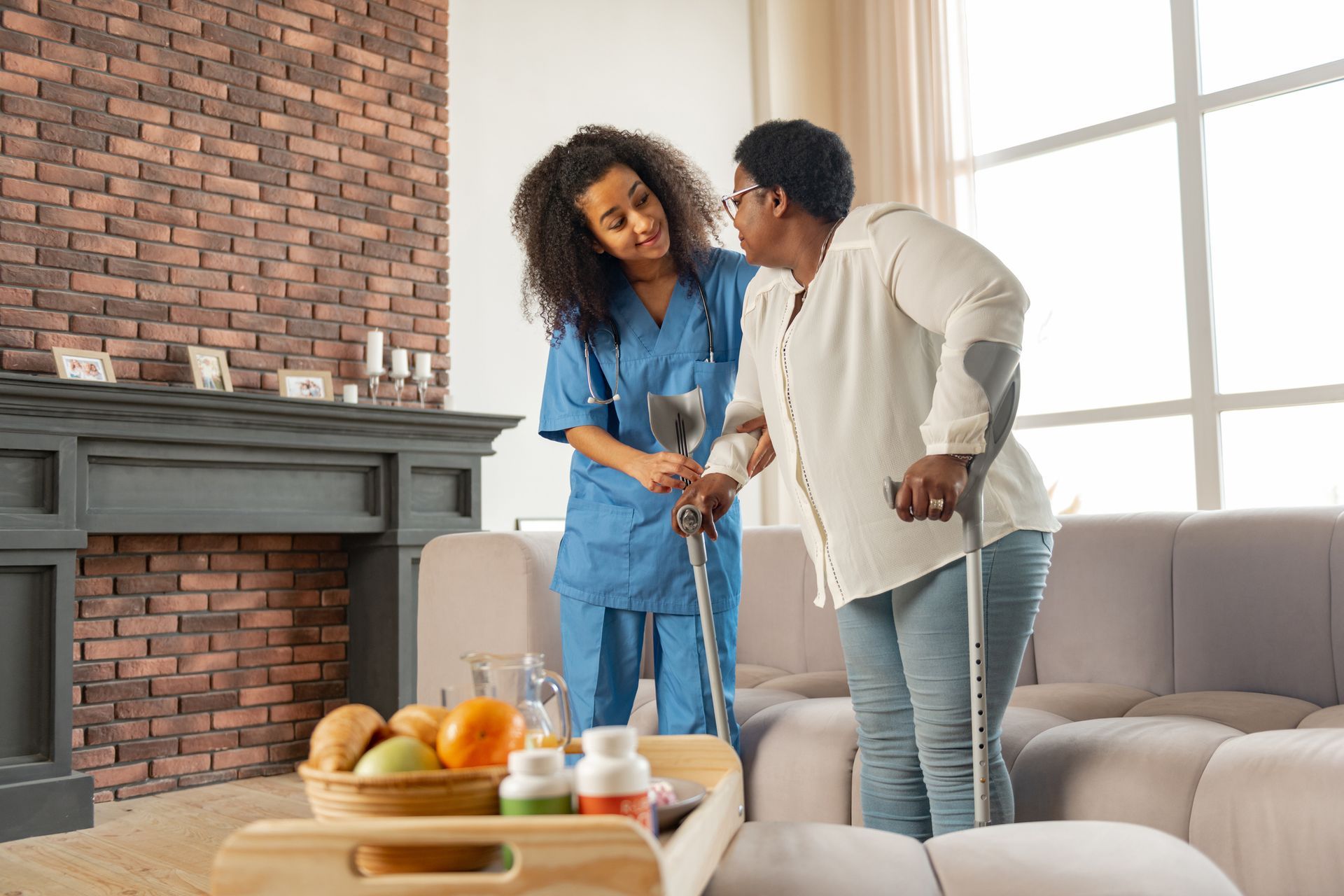 Woman is Helping an Older Woman with a Walker into a House — Fishers, IN — Alluring Warmth Home Care LLC Woman is Helping an Older Woman with a Walker into a House — Fishers, IN — Alluring Warmth Home Care LLC