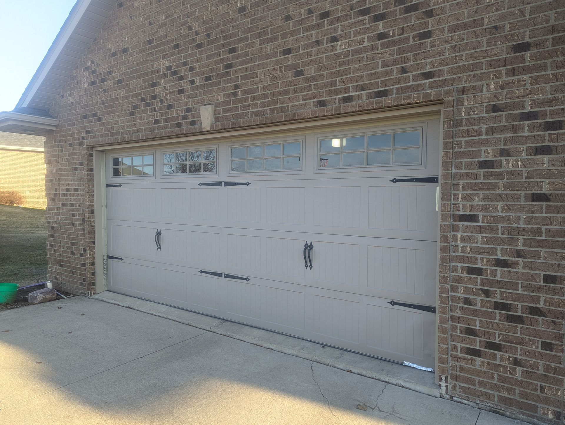 White double garage door on a brick house in daylight