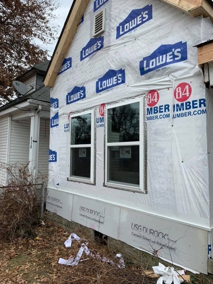 House under construction with Lowe’s house wrap and uncovered windows.