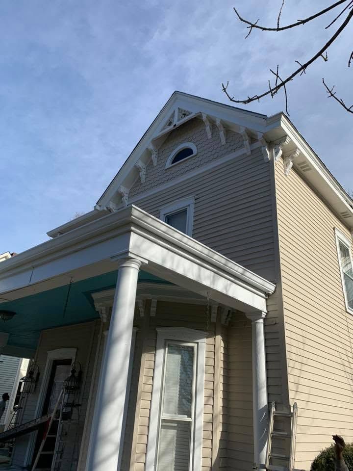 Gray house with white trim and porch columns under a blue sky