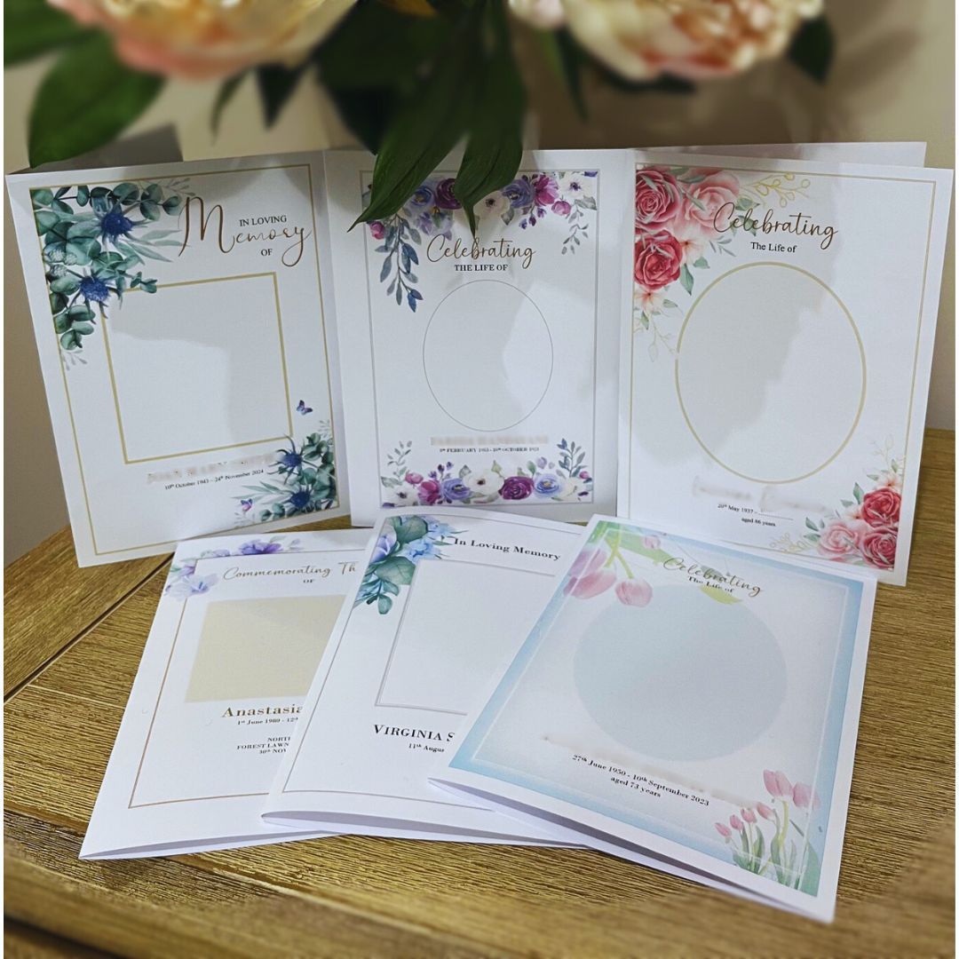 A bunch of cards are sitting on a table with flowers in the background