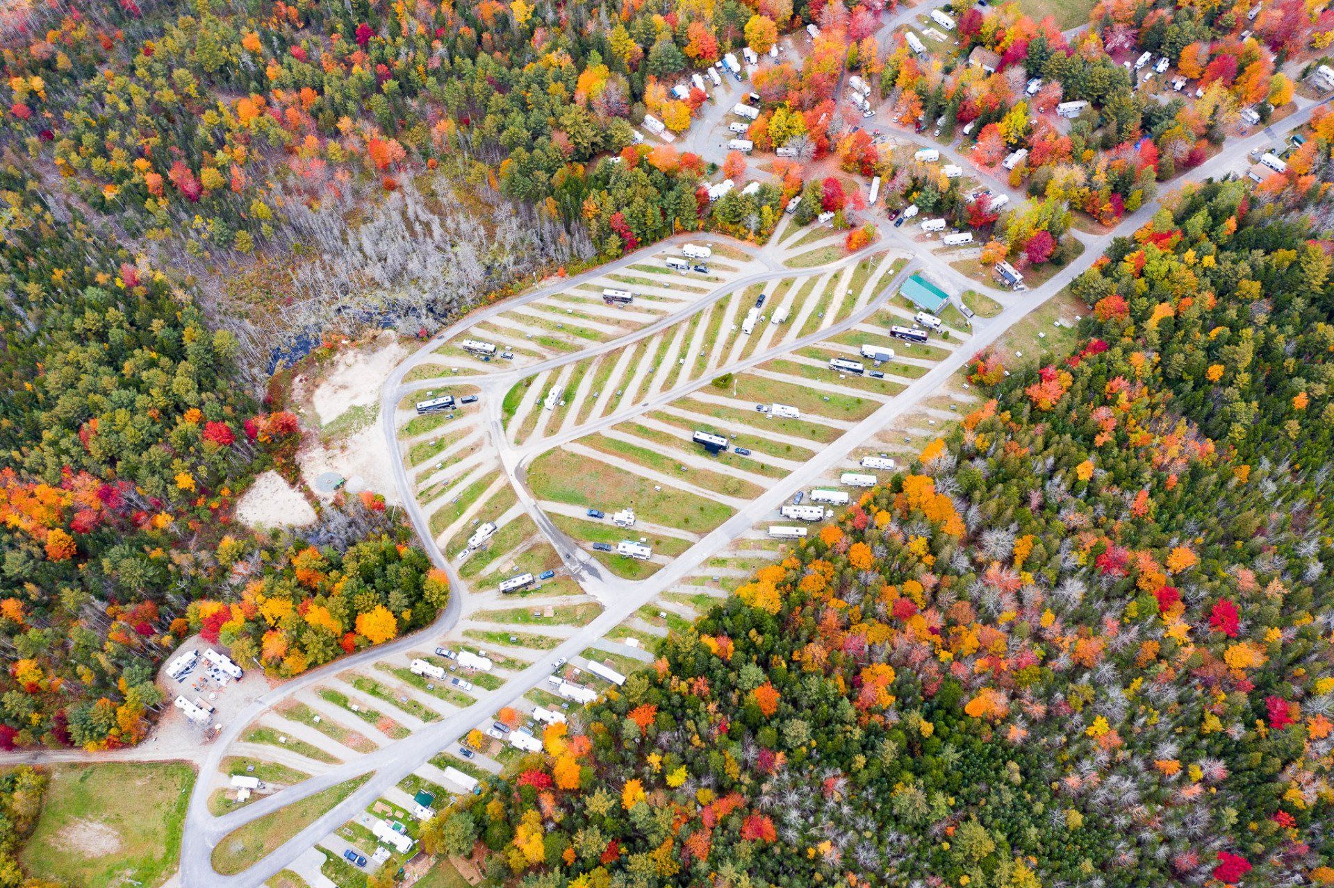 Aerial view of a winding ski slope through a colorful autumn forest