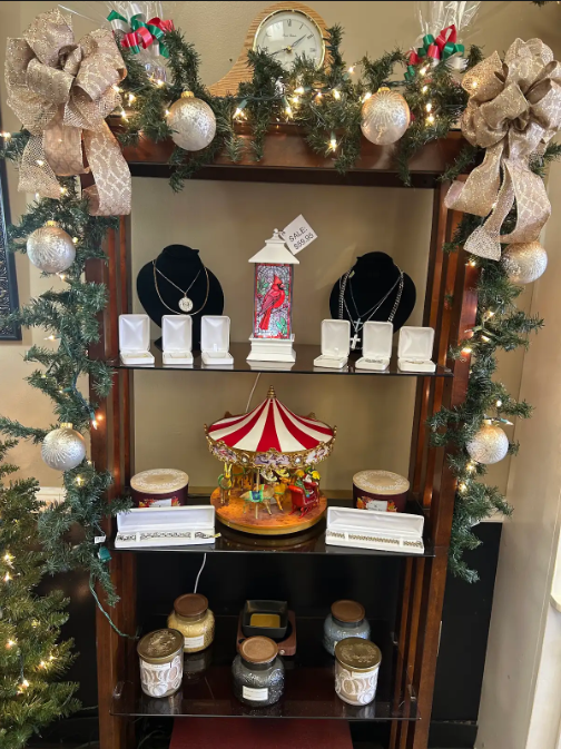 Jewelry display case with Christmas garland, necklaces, carousel, candles.