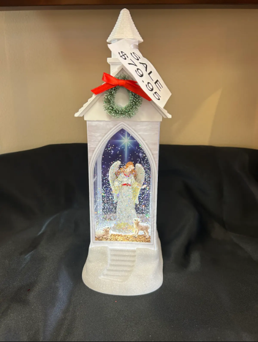 White church figurine with angel inside, on sale for $79.95. Red bow and green wreath.