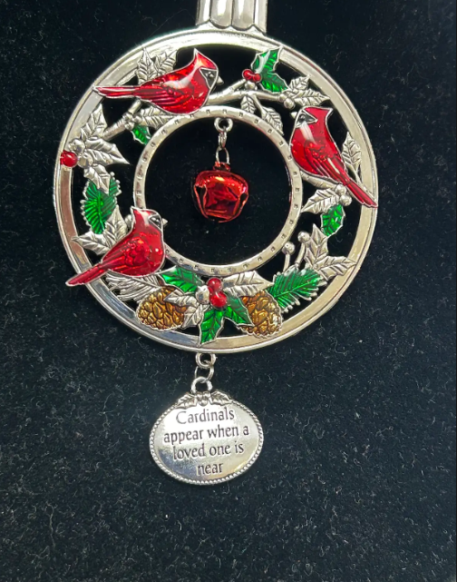 Silver cardinal ornament with red birds, holly, pinecones, and a red bell; message: