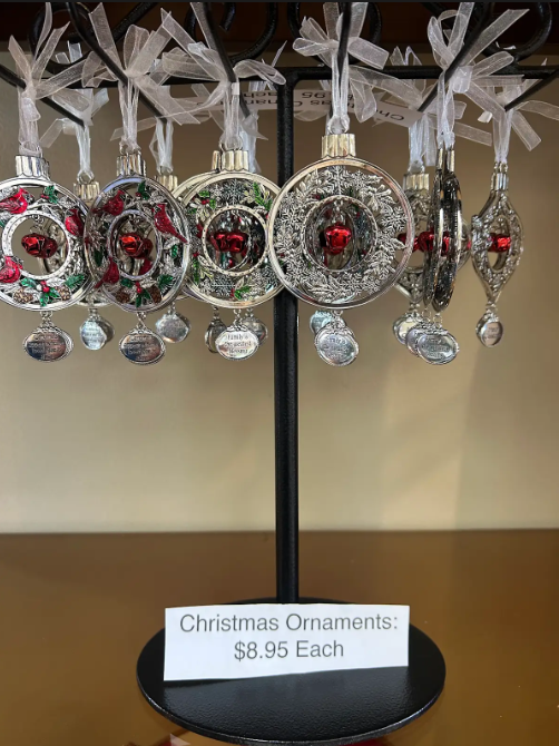 Christmas ornaments hanging on a black display stand, price $8.95 each.