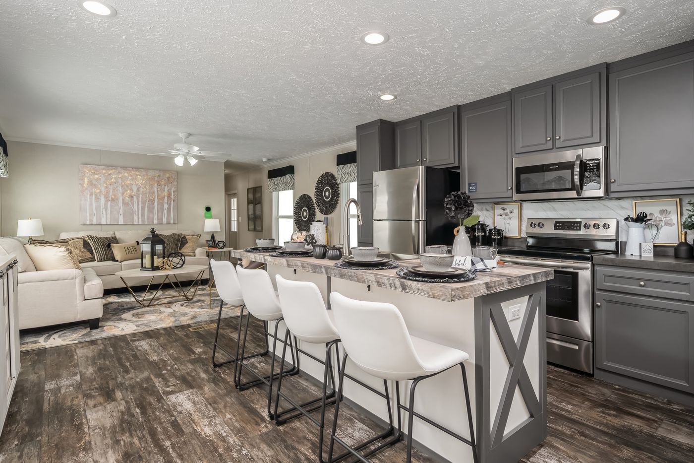 A kitchen with stainless steel appliances and a large island in the middle of the room.