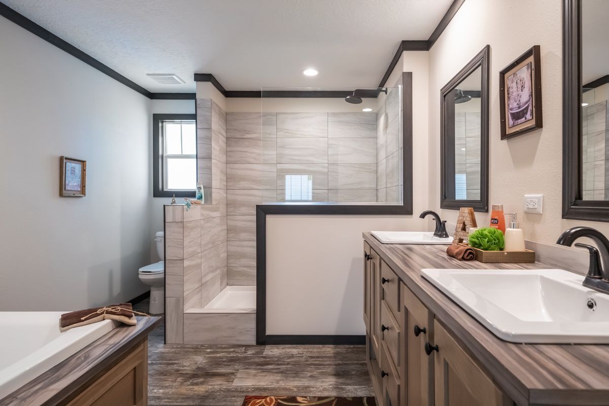 A bathroom with two sinks and a walk in shower.