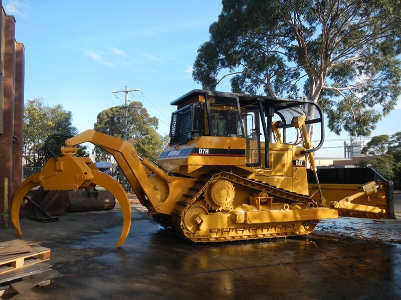 A yellow cat bulldozer is parked in a parking lot