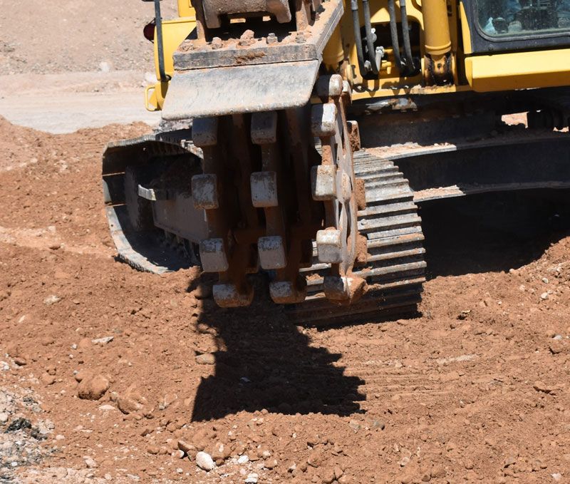 A yellow bulldozer is working on a dirt road