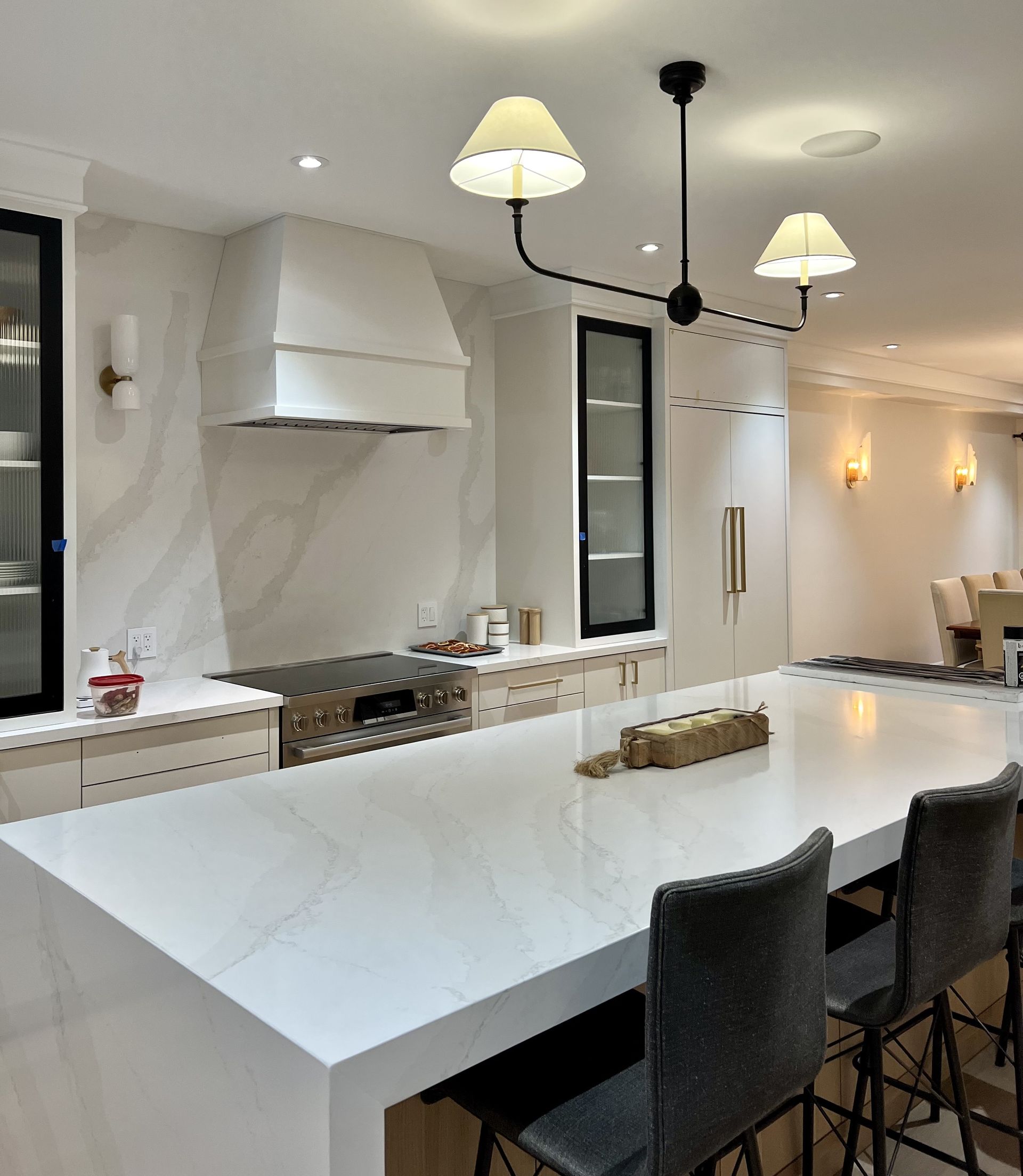A kitchen with a large white table and chairs