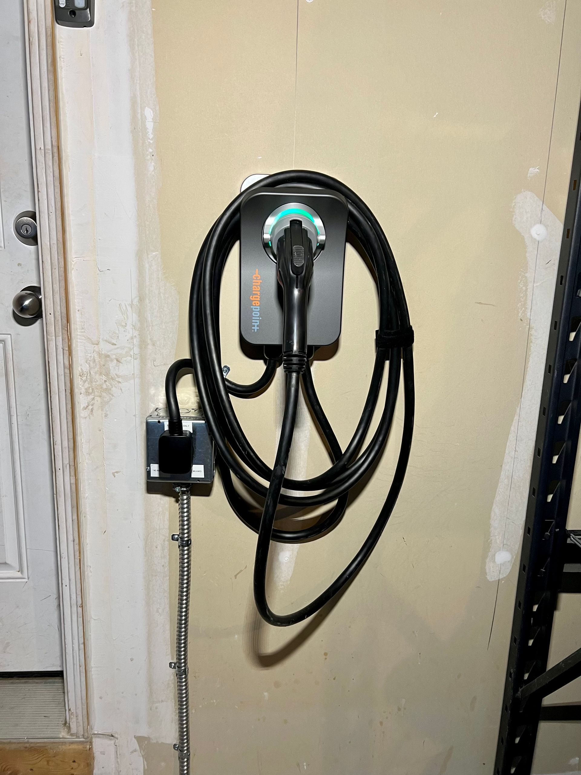 A plug with a cord attached to it is hanging on a wall.