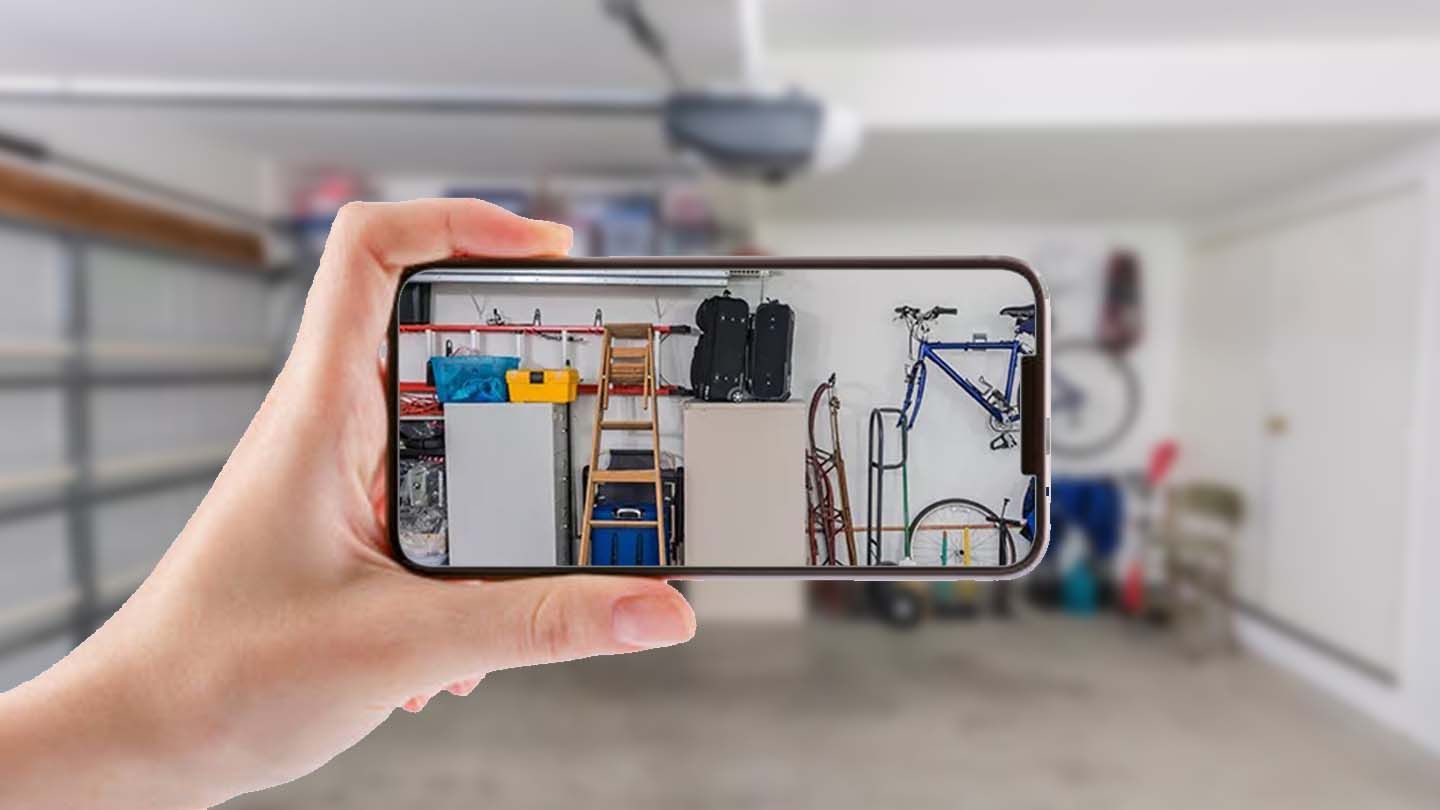 A person is taking a picture of a garage with a cell phone.