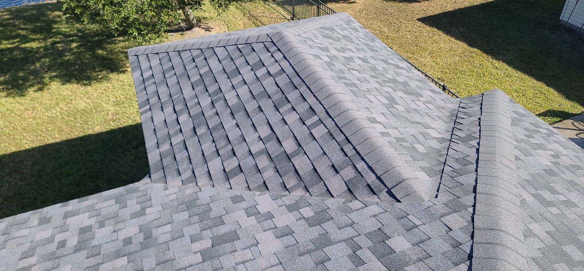 Overhead view of a house roof with gray shingles.