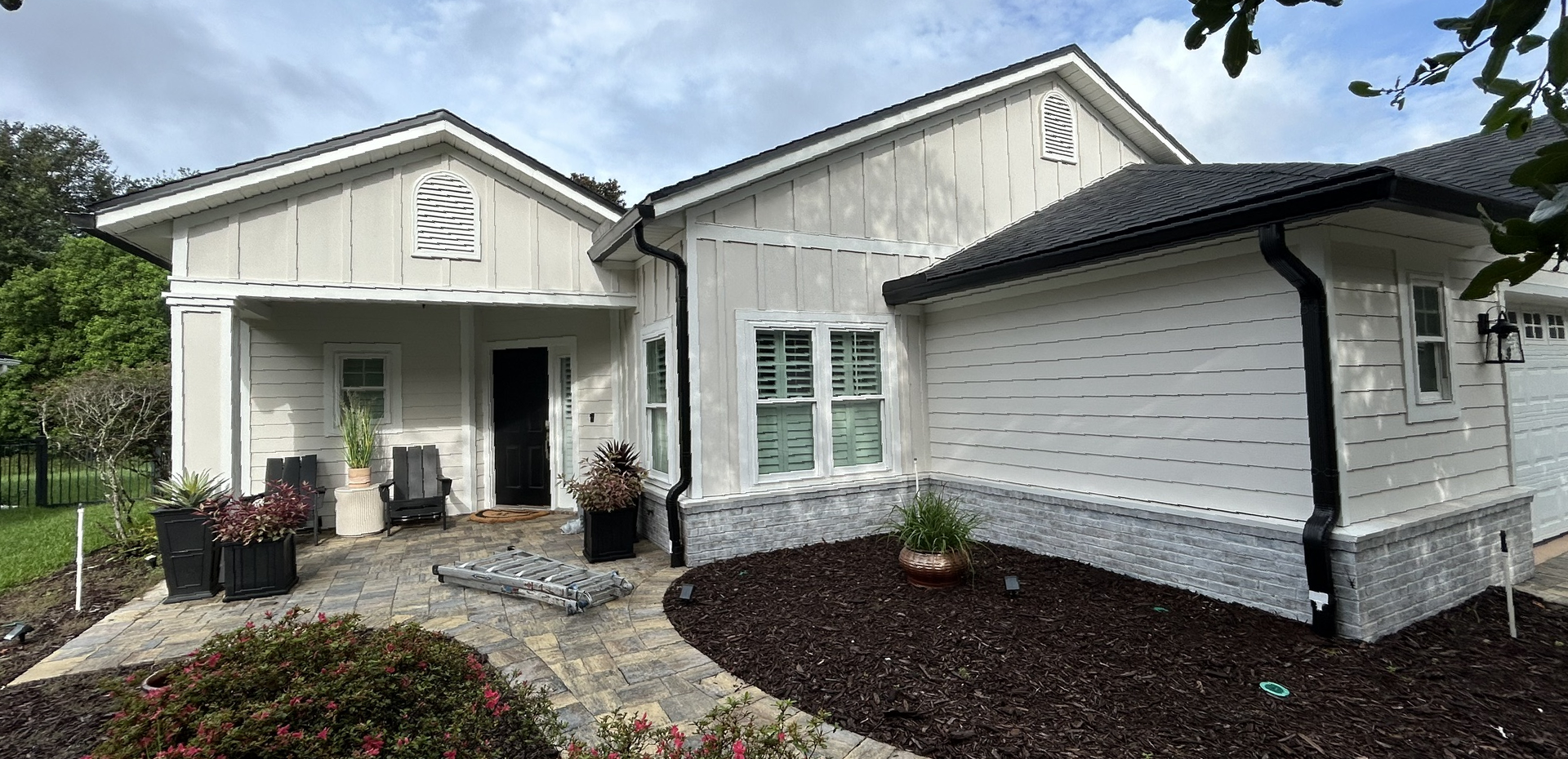 A light-colored house with a dark roof and trim.