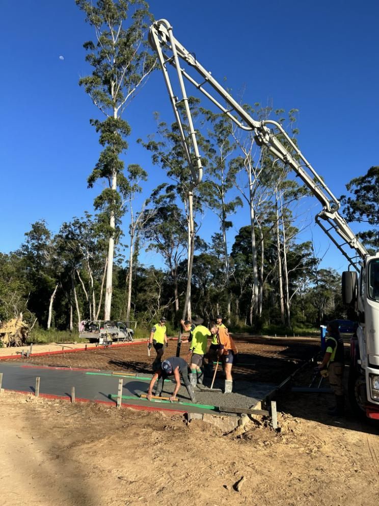 A Group Of Construction Workers Are Working On A Road — Hinterland Concreting Pty Ltd In Lennox Head, NSW