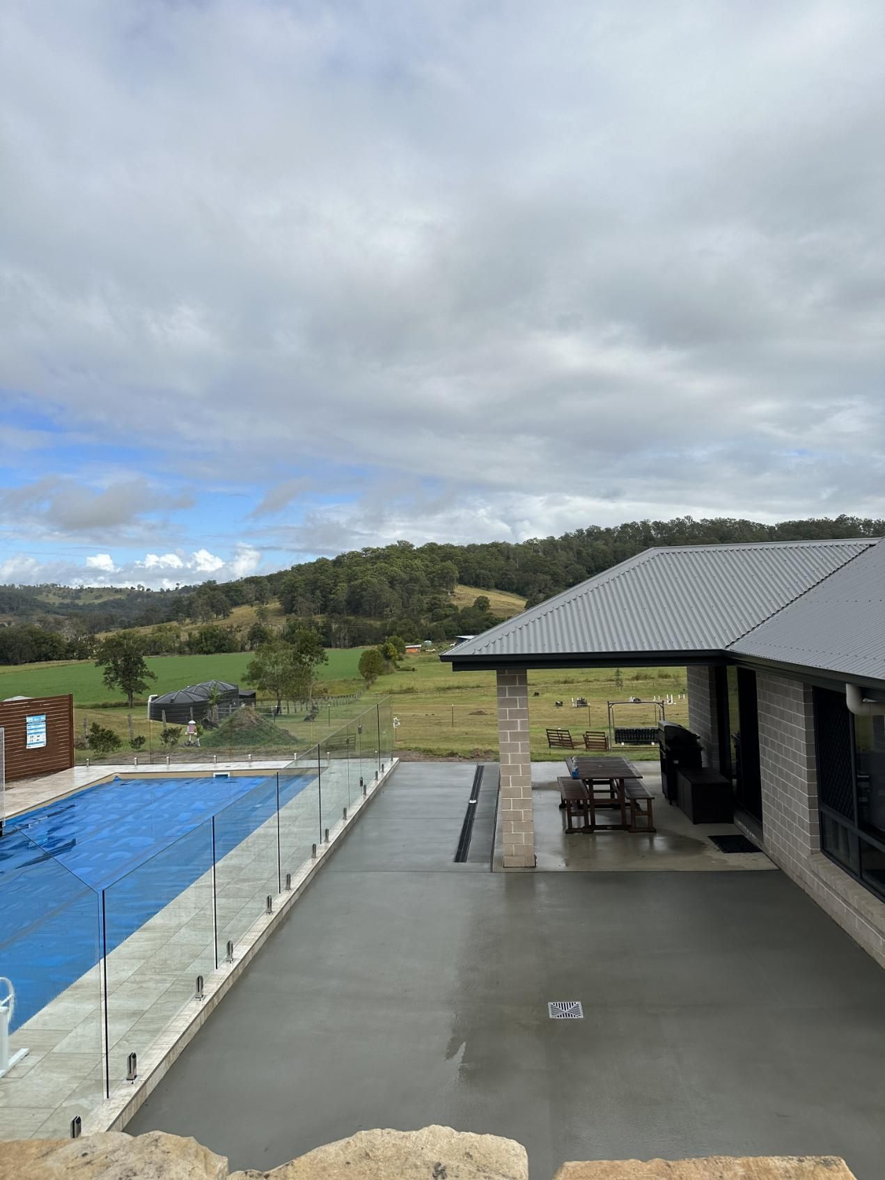 A House With A Swimming Pool In Front Of It — Hinterland Concreting Pty Ltd In Lennox Head, NSW