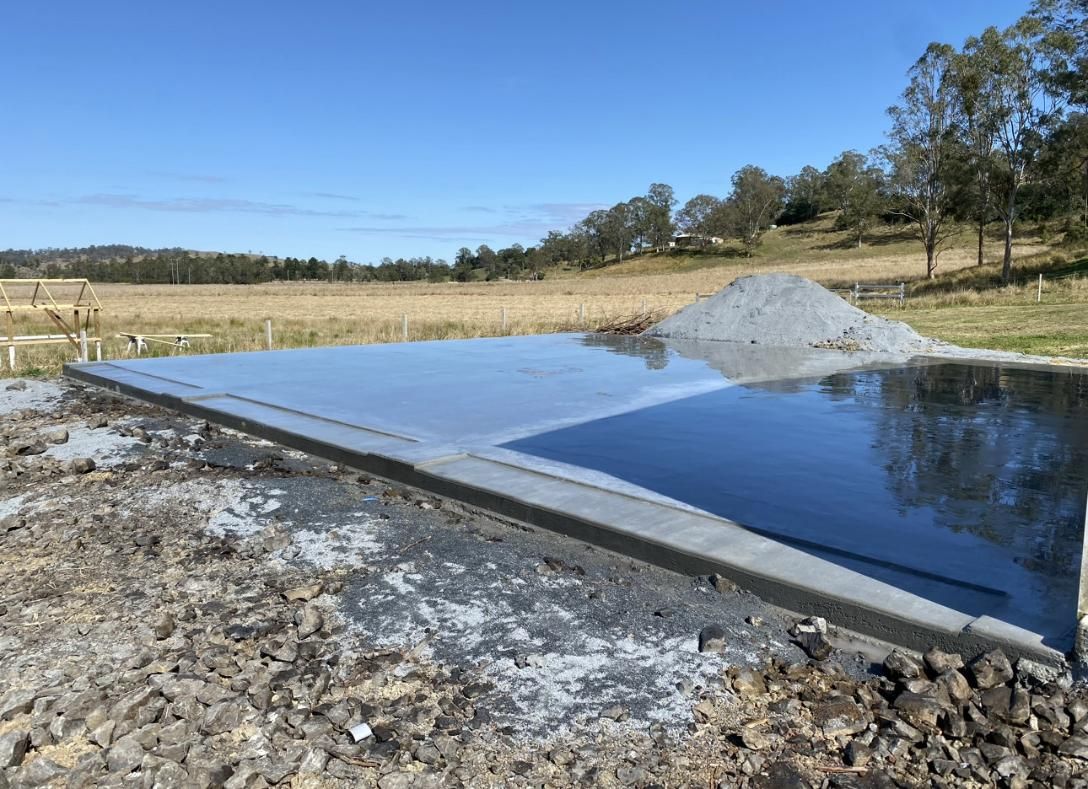 A Large Concrete Slab Is Sitting On Top Of A Dirt Field — Hinterland Concreting Pty Ltd In Lennox Head, NSW