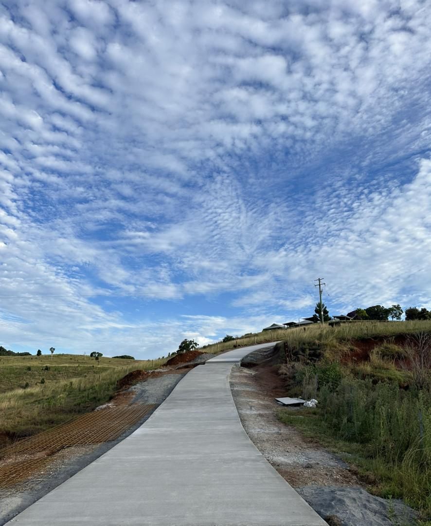 A Concrete Road Going Through A Field With A Cloudy Sky In The Background — Hinterland Concreting Pty Ltd In Lennox Head, NSW