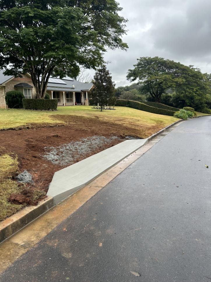 A House Is Being Built On A Hill Next To A Road — Hinterland Concreting Pty Ltd In Lennox Head, NSW