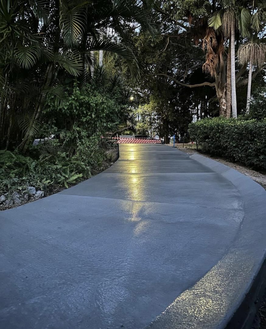 A Concrete Walkway In A Park Surrounded By Trees And Bushes — Hinterland Concreting Pty Ltd In Lennox Head, NSW
