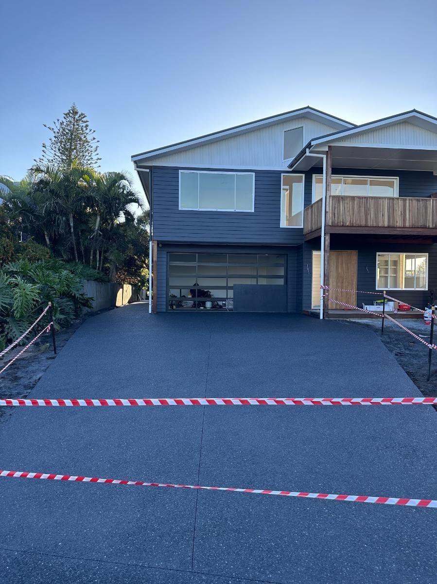 A Large House With A Concrete Driveway In Front Of It — Hinterland Concreting Pty Ltd In Lennox Head, NSW