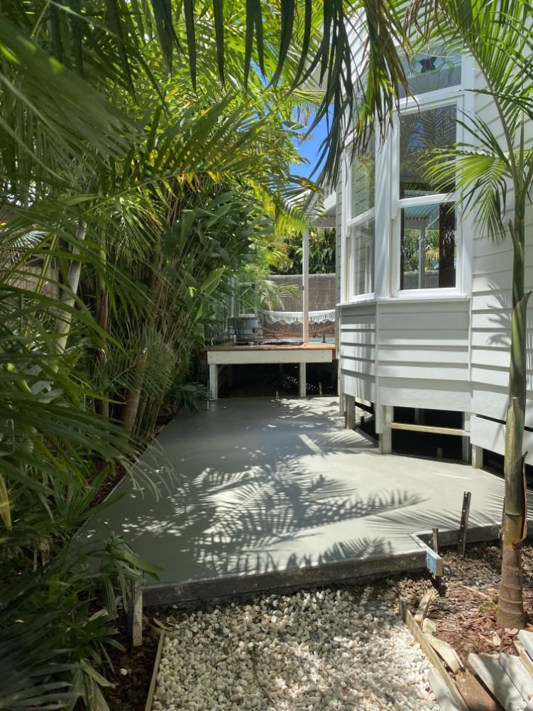 A Concrete Walkway Leading To A House Surrounded By Palm Trees — Hinterland Concreting Pty Ltd In Lennox Head, NSW