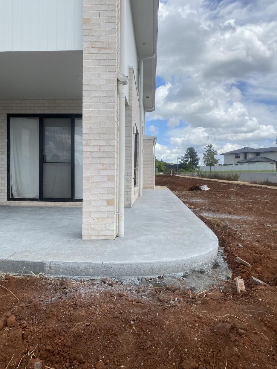 A Brick House With A Concrete Sidewalk In Front Of It — Hinterland Concreting Pty Ltd In Lennox Head, NSW