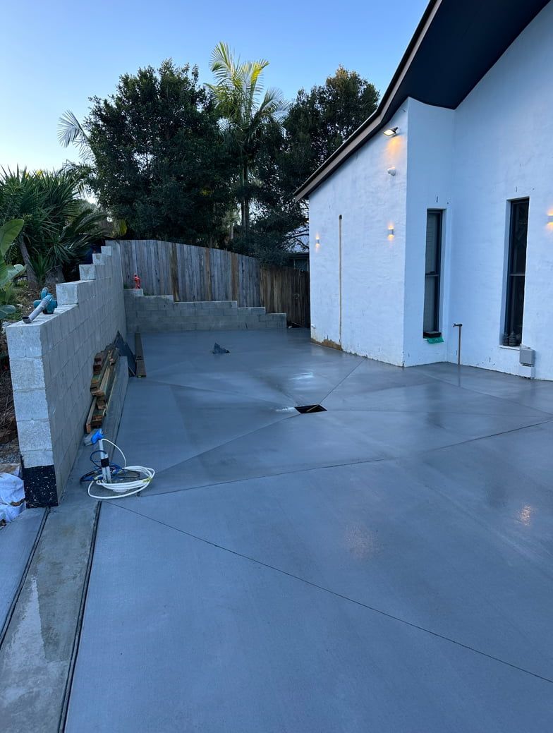 A White House With A Concrete Driveway In Front Of It — Hinterland Concreting Pty Ltd In Lennox Head, NSW