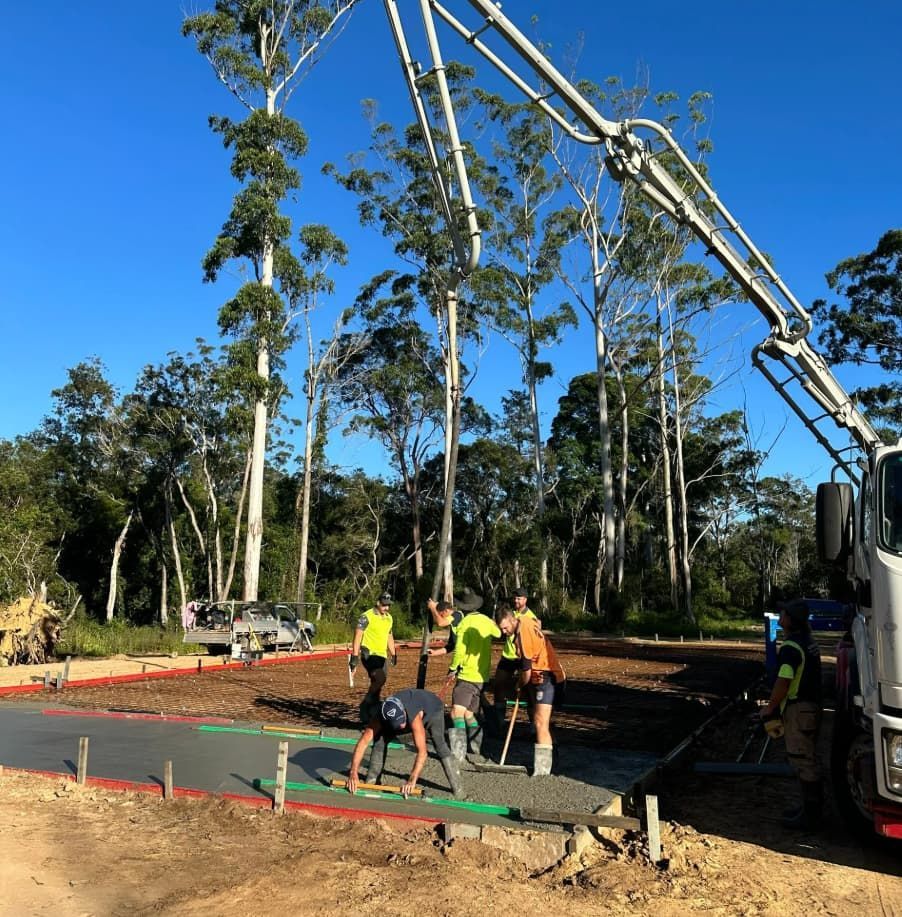 A Group Of Construction Workers Are Working On A Concrete Driveway — Hinterland Concreting Pty Ltd In Lennox Head, NSW