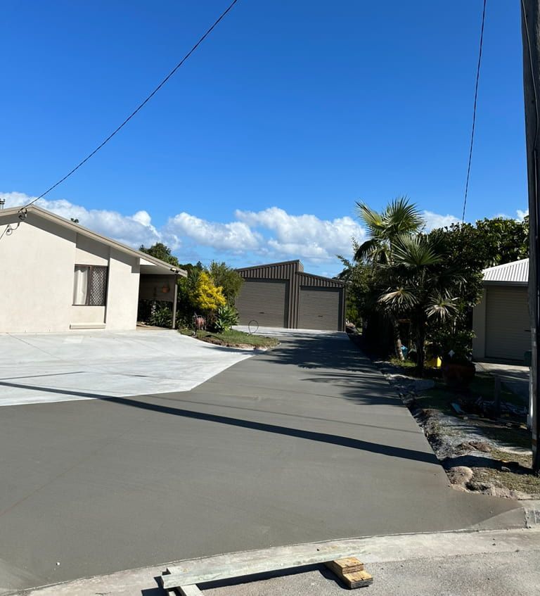 A Concrete Driveway With A House In The Background — Hinterland Concreting Pty Ltd In Lennox Head, NSW