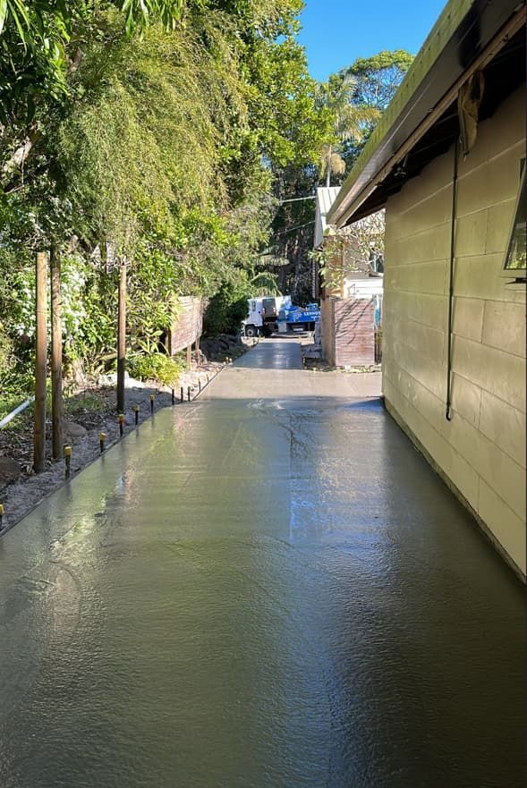 A Concrete Walkway Leading To A House With A Truck In The Background — Hinterland Concreting Pty Ltd In Lennox Head, NSW