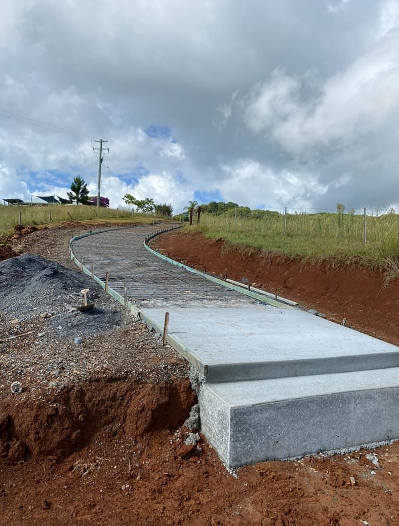 A Concrete Walkway Is Being Built On Top Of A Dirt Hill — Hinterland Concreting Pty Ltd In Lennox Head, NSW