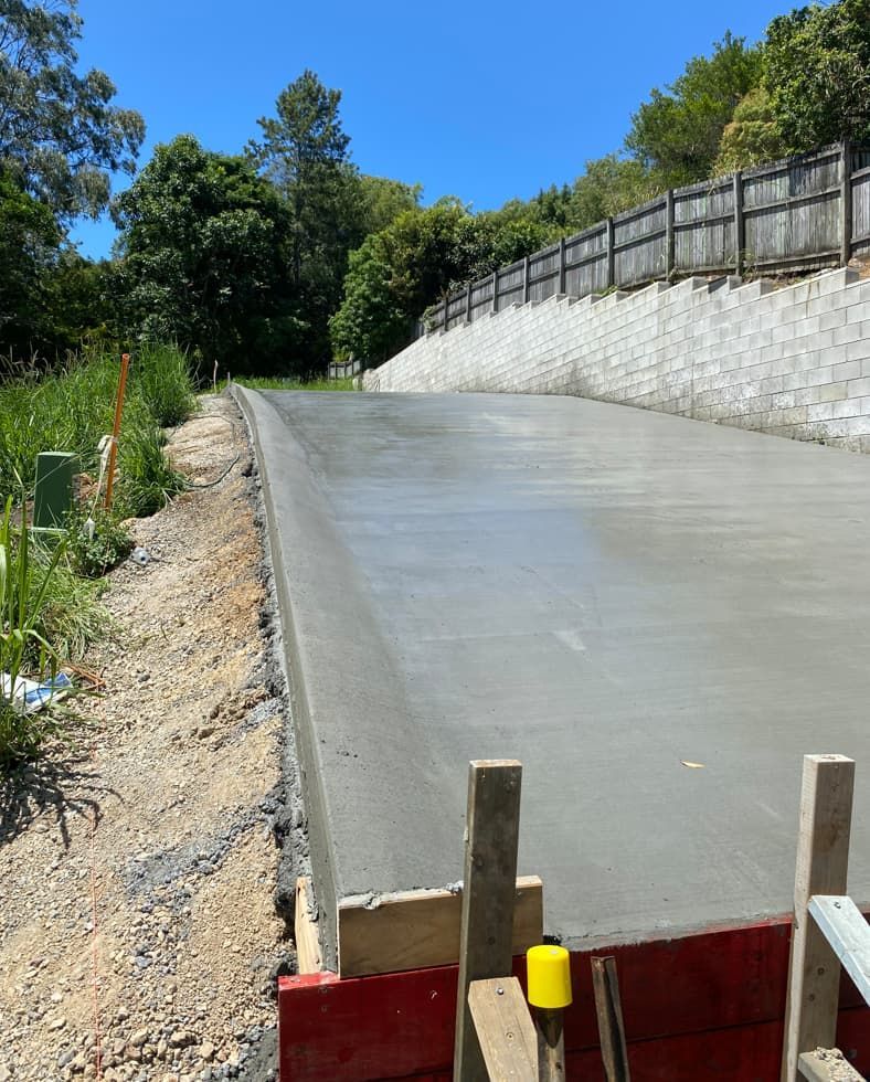 A Concrete Road Is Being Built Next To A Fence — Hinterland Concreting Pty Ltd In Lennox Head, NSW