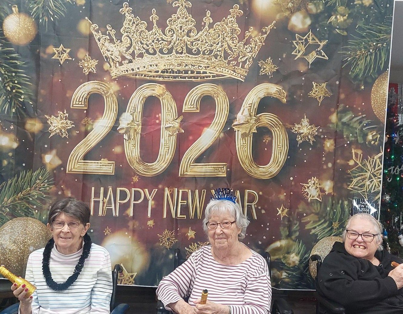Three smiling people sit in front of a festive 