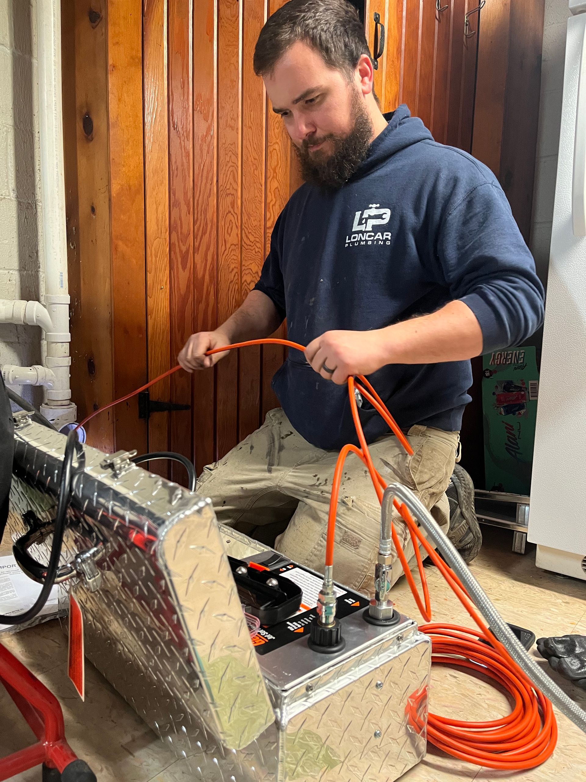 a man in a blue hoodie is working on a machine .