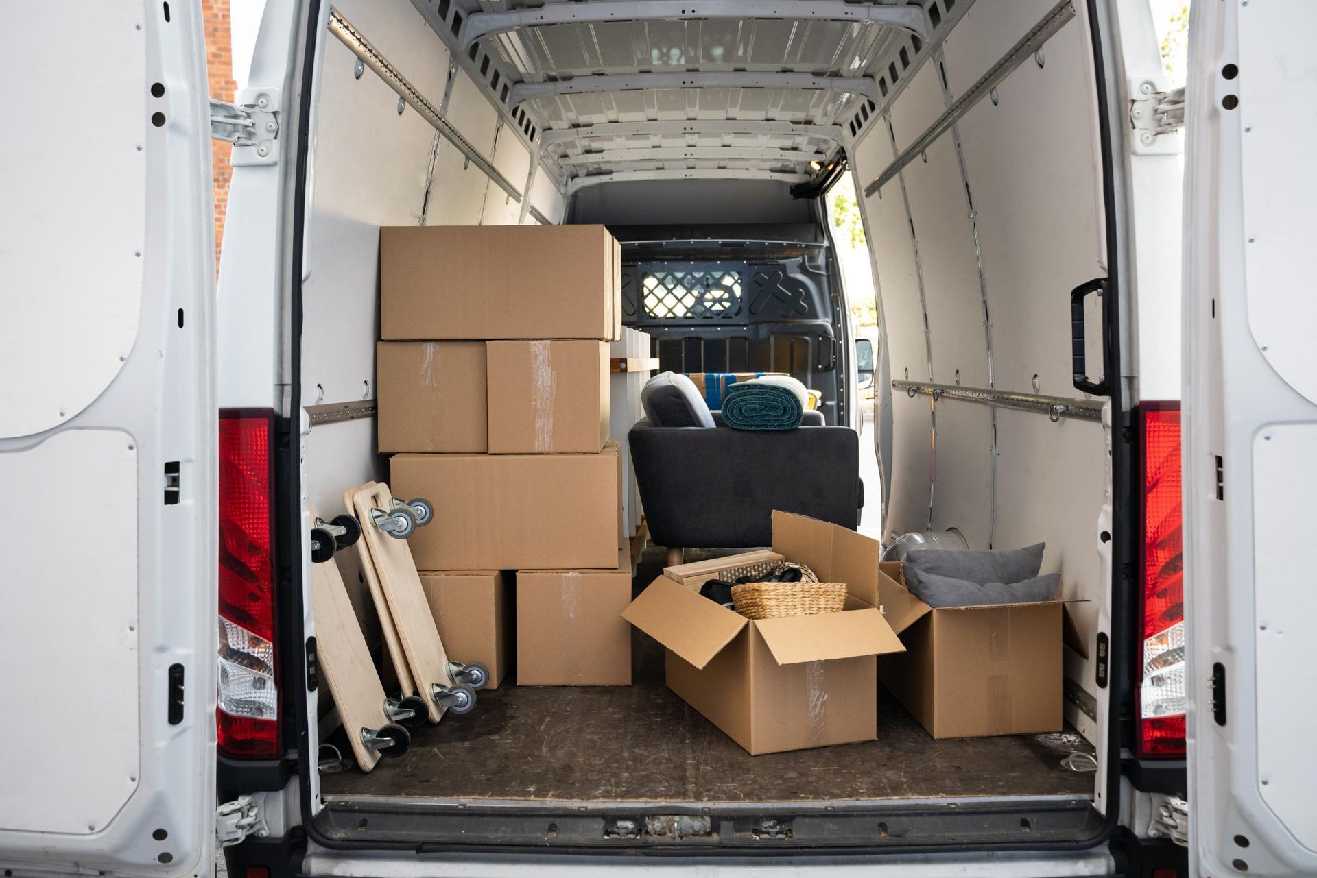 Boxes and moving supplies inside the back of a white cargo van