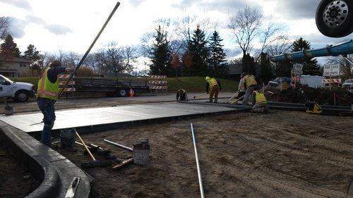 A group of construction workers are working on a concrete floor.