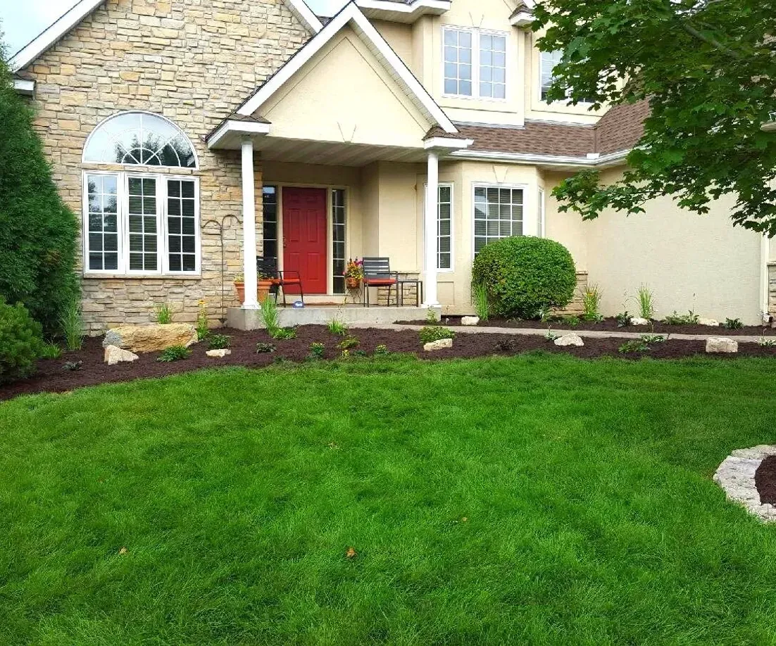 A large house with a lush green lawn in front of it.