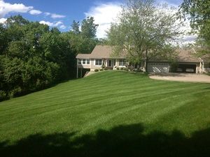 A house with a large lush green lawn in front of it.